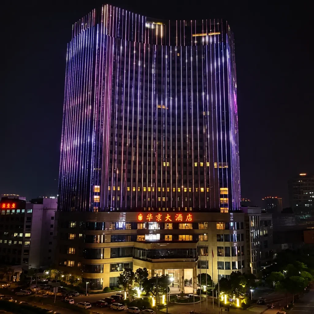 Hotel building facade lighting project with outdoor linear pixel lights, full-color dynamic purple-blue gradient lighting effect creating modern elegant exterior atmosphere